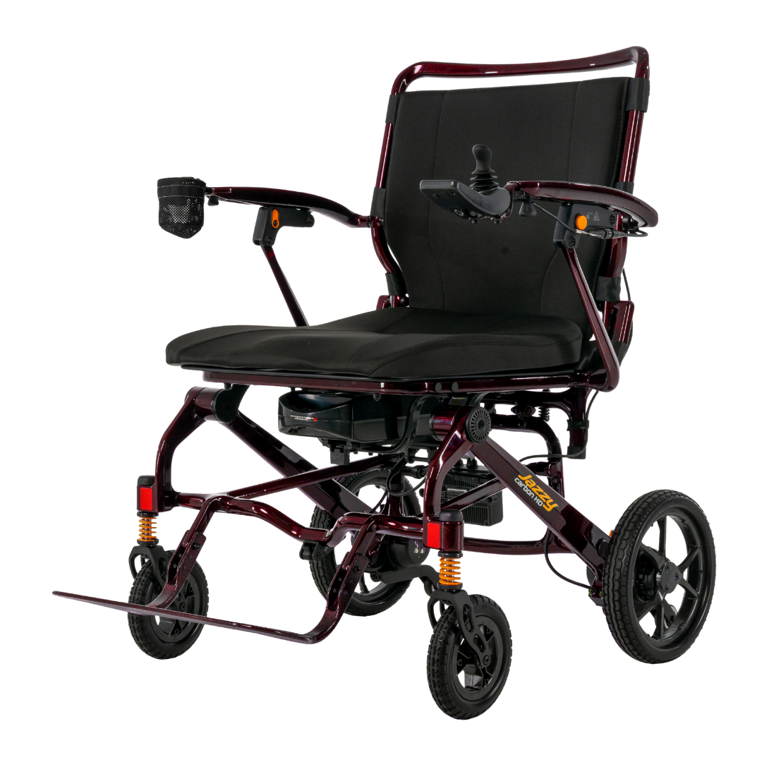 The Pride Jazzy Carbon HD Bariatric Portable Powerchair is a modern, lightweight travel power chair with a black seat, maroon frame, right-armrest joystick control, footrest, and four wheels for superior stability and mobility.